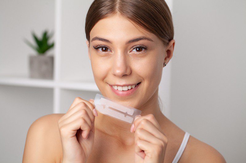 teeth-whitening-beautiful-smiling-woman-holding-whitening-strip-1.jpg