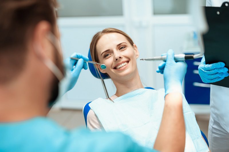 woman-sits-dental-chair-doctors-bowed-her.jpg
